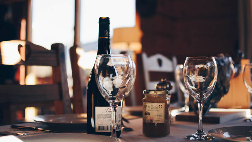 A table with wine glasses and a bottle of wine.