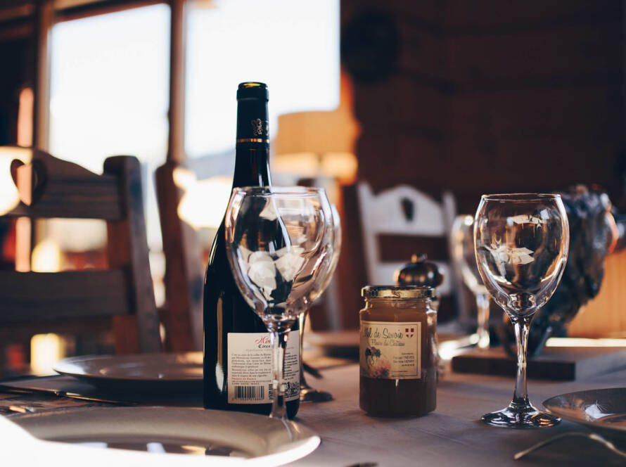 A table with wine glasses and a bottle of wine.