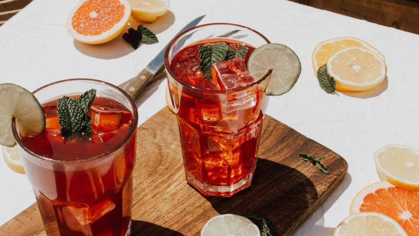 Two glasses of iced tea on a table.