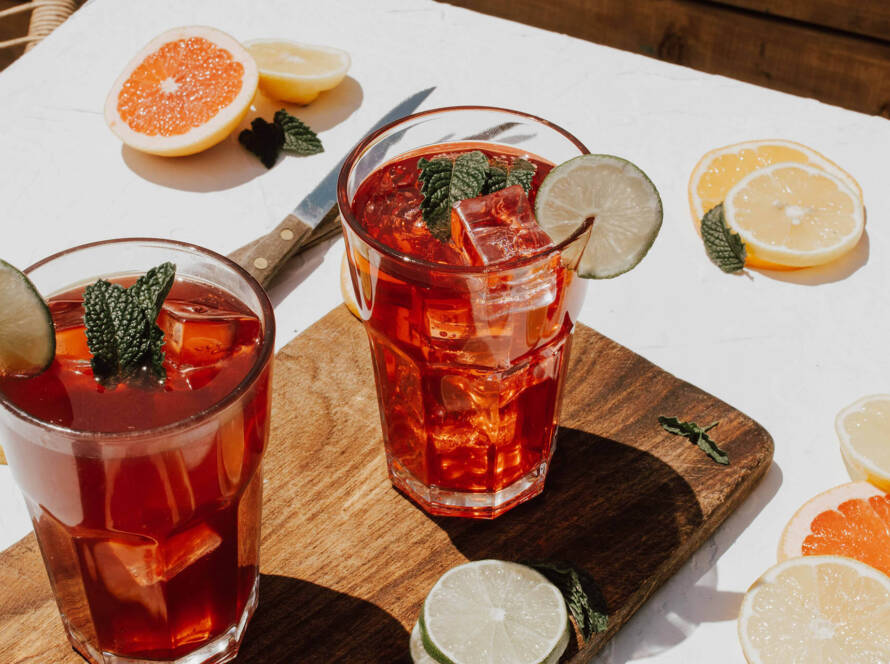 Two glasses of iced tea on a table.